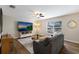 Cozy living room with wood-look floors, a large screen television, and a comfortable gray couch at 4255 67Th Avenue E Cir, Sarasota, FL 34243