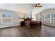 Light-filled bedroom with hardwood floors, ceiling fan, and two large windows at 4255 67Th Avenue E Cir, Sarasota, FL 34243