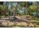 Community playground with picnic tables, swings, and a slide surrounded by mature trees and natural landscaping at 4255 67Th Avenue E Cir, Sarasota, FL 34243