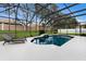 Inviting screened-in pool area featuring stylish deck chairs and lush landscaping at 4255 67Th Avenue E Cir, Sarasota, FL 34243