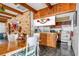 Rustic kitchen featuring wood beams, brick accent wall, breakfast bar, and white appliances at 4414 Spicewood Dr # H, Bradenton, FL 34208