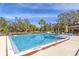 Large community swimming pool surrounded by lounge chairs and palm trees at 4414 Spicewood Dr # H, Bradenton, FL 34208