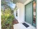 Inviting front entrance with a stylish sage-colored door and lush tropical landscaping at 4744 105Th E Ave, Parrish, FL 34219