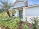Front entrance featuring a blue door and lush landscaping with various plants and mulch at 4744 105Th E Ave, Parrish, FL 34219