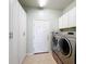 Well-equipped laundry room featuring front-loading washer/dryer, tile flooring, and ample white cabinets at 4744 105Th E Ave, Parrish, FL 34219