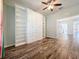 Bright living room features beautiful built-in shelving and drawers, ceiling fan, and lovely hardwood-style floors at 4744 105Th E Ave, Parrish, FL 34219