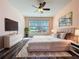 Lovely main bedroom with gorgeous natural light, hardwood-style flooring, and TV at 4744 105Th E Ave, Parrish, FL 34219