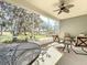 Screened-in porch featuring a ceiling fan and comfortable outdoor seating with views of the landscaped yard at 4744 105Th E Ave, Parrish, FL 34219