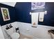 Stylish powder room featuring beadboard wainscoting, navy walls and designer fixtures at 5118 78Th St E Cir, Bradenton, FL 34203