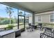 Screened porch with seating and a view of the backyard with trees at 5119 Admiral Pointe Dr, Apollo Beach, FL 33572