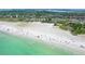 Expansive aerial view of the beachfront showcasing the shoreline and the surrounding neighborhood at 5525 Shadow Lawn Dr, Sarasota, FL 34242