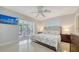 Spacious bedroom featuring terrazzo flooring, a ceiling fan, and sliding glass doors to the patio at 5525 Shadow Lawn Dr, Sarasota, FL 34242