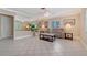Bright and airy living room boasts tile floors, neutral colors, and abundant natural light from large windows at 5525 Shadow Lawn Dr, Sarasota, FL 34242