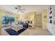 Inviting living room with tile flooring, a comfortable blue sofa, and a view of the screened lanai at 5525 Shadow Lawn Dr, Sarasota, FL 34242