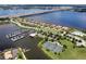Community aerial view showcasing homes along the water, marina with boat slips, tennis courts, and the bridge in the background at 5608 Tidewater Preserve Blvd, Bradenton, FL 34208