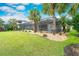 Expansive backyard with lush lawn, mature trees, and screened-in lanai with outdoor furniture at 5608 Tidewater Preserve Blvd, Bradenton, FL 34208