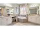 Bright bathroom featuring a corner tub, double sinks, and plantation shutters for privacy and light control at 5608 Tidewater Preserve Blvd, Bradenton, FL 34208