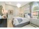 This cozy bedroom features a modern chandelier, soft pastel walls, and tasteful decor for a calming space at 5608 Tidewater Preserve Blvd, Bradenton, FL 34208