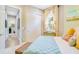 Light-filled bedroom with a patterned comforter, colorful curtains, and access to the hallway at 5608 Tidewater Preserve Blvd, Bradenton, FL 34208