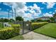 Gated community dog park with manicured lawn, lush hedges, and walking path under a bright, cloudy sky at 5608 Tidewater Preserve Blvd, Bradenton, FL 34208