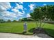Dog waste station on a lush green community lawn, with a house and blue skies in the background at 5608 Tidewater Preserve Blvd, Bradenton, FL 34208