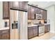 Stainless steel refrigerator and gas range set in a modern kitchen with gray cabinets and quartz counters at 5608 Tidewater Preserve Blvd, Bradenton, FL 34208