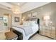 Relaxing main bedroom featuring neutral walls, an elegant chandelier, and a luxurious king-size bed with a soft patterned comforter at 5608 Tidewater Preserve Blvd, Bradenton, FL 34208