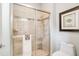 Modern bathroom featuring glass-enclosed shower with neutral-toned tiling and a decorative accent band at 5608 Tidewater Preserve Blvd, Bradenton, FL 34208