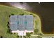 Aerial view of the community tennis courts with lush green surroundings and waterfront views at 5608 Tidewater Preserve Blvd, Bradenton, FL 34208