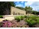 Stone signage marks 'The Meadows' community entrance, framed by lush landscaping and vibrant pink flowers at 5655 Downham Mdws, Sarasota, FL 34235