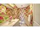 Vibrant powder room with a decorative mirror, cabinet, and lively tropical-themed wallpaper at 614 Tropical Cir, Sarasota, FL 34242