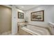 Luxury bathroom featuring soaking tub, shower, tiled floors, and decorative art at 614 Tropical Cir, Sarasota, FL 34242
