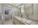 Bright bathroom featuring double sinks, a marble countertop, and modern fixtures at 614 Tropical Cir, Sarasota, FL 34242