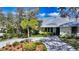 Charming single-story home with lush landscaping, a paved driveway, and a metal roof at 614 Tropical Cir, Sarasota, FL 34242