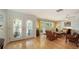Bright and airy living room featuring hardwood floors, a ceiling fan, and decorative glass front doors at 614 Tropical Cir, Sarasota, FL 34242