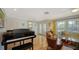 Bright living area featuring a piano, comfortable seating, and large windows at 614 Tropical Cir, Sarasota, FL 34242