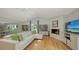 Spacious living room with fireplace, bookcases, and view to kitchen and dining area at 614 Tropical Cir, Sarasota, FL 34242