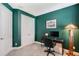 Room featuring green walls, a work desk, a modern lamp, and a closet space with white double doors at 6378 Grandview Hill Ct, Bradenton, FL 34203