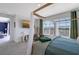 Comfortable bedroom with a four-poster bed, plush seating, and ample natural light at 6378 Grandview Hill Ct, Bradenton, FL 34203