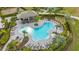 Aerial view of the community pool with lush landscaping, lounge chairs, and a covered pavilion at 6378 Grandview Hill Ct, Bradenton, FL 34203