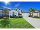 Beautiful white home with lush landscaping, palm trees, and well-manicured lawn on a sunny day at 6378 Grandview Hill Ct, Bradenton, FL 34203