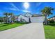 Charming white home with a well-manicured lawn, beautiful landscaping, and a spacious driveway on a sunny day at 6378 Grandview Hill Ct, Bradenton, FL 34203