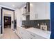 Modern kitchen featuring white cabinetry, stainless steel range hood and decorative tiled backsplash at 6378 Grandview Hill Ct, Bradenton, FL 34203