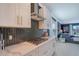 Modern kitchen featuring white cabinetry, stainless steel range hood and decorative tiled backsplash at 6378 Grandview Hill Ct, Bradenton, FL 34203