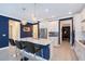 This kitchen has a large island with seating, stainless steel appliances, and stunning hanging lights at 6378 Grandview Hill Ct, Bradenton, FL 34203