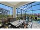 Screened lanai with a dining area, overlooking the pool, spa and beautiful lake at 6378 Grandview Hill Ct, Bradenton, FL 34203