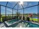 Inviting spa and pool in a screened-in lanai, perfect for relaxation with a view of the lake at 6378 Grandview Hill Ct, Bradenton, FL 34203