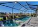 Sparkling pool and spa in screened lanai, providing stunning lake views and an outdoor kitchen at 6378 Grandview Hill Ct, Bradenton, FL 34203