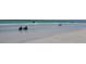 Inviting beach scene with gentle waves, and people in beach chairs in a relaxing waterfront setting at 6415 Midnight Pass Rd # 904, Sarasota, FL 34242