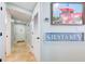 Light and airy hallway featuring travertine flooring, coastal artwork, and easy access to the entry door at 6415 Midnight Pass Rd # 904, Sarasota, FL 34242